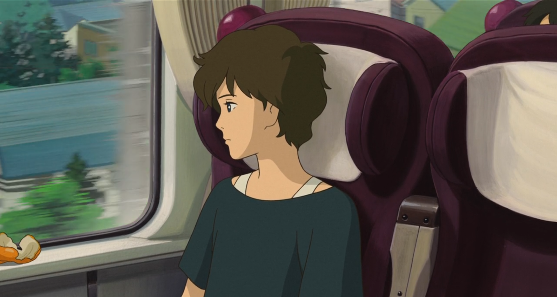 Scène de Souvenirs de Marnie
Anna, jeune fille de douze ans, cheveux bruns assez courts, portant un haut noir un peu large au niveau des épaules laissant apparaitre des brettelles blanches, assise sur un siège de train couleur bordeaux avec un tissu blanc au niveau de la tête, regardant d'un air un peu absent le paysage, principalement constitué de maisons aux toits bleus et de sapins, défiler par la fenêtre du train au rebord de laquelle on aperçoit des épluchures d'orange.