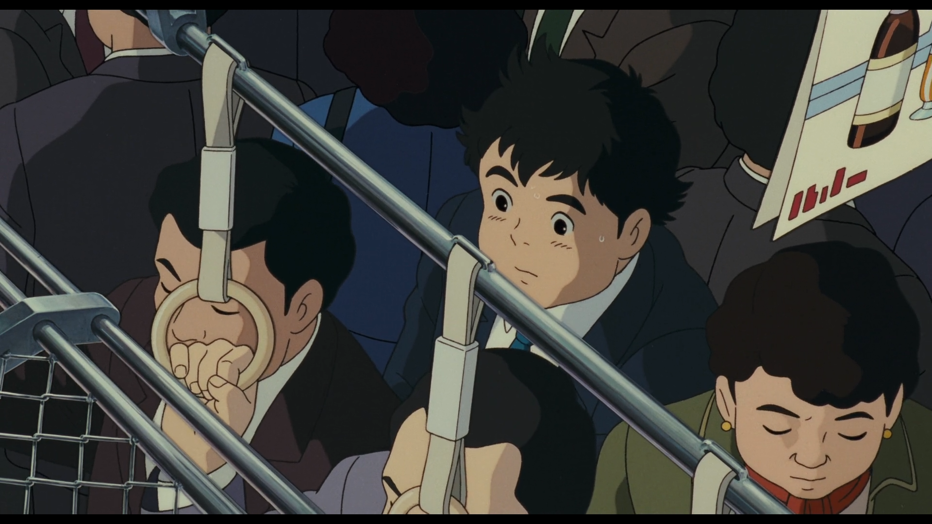 Scène de Pompoko
Shokichi, héros du film, sous les traits d'un jeune homme japonais, cheveux noirs en bataille, yeux noirs, visage rond, la mine un brin désabusée, en costume/cravate bleus avec une chemise blanche.
On le voit en contre-plongée, dans un métro bondé, entouré entre autre d'un homme en costume noir, d'une femme avec une veste vert foncé, et d'un homme en gris qui se tient à une rambarde bien en évidence.
On aperçoit aussi une pancarte publicitaire en haut à gauche pour une boisson dont ne distingue pas la marque
