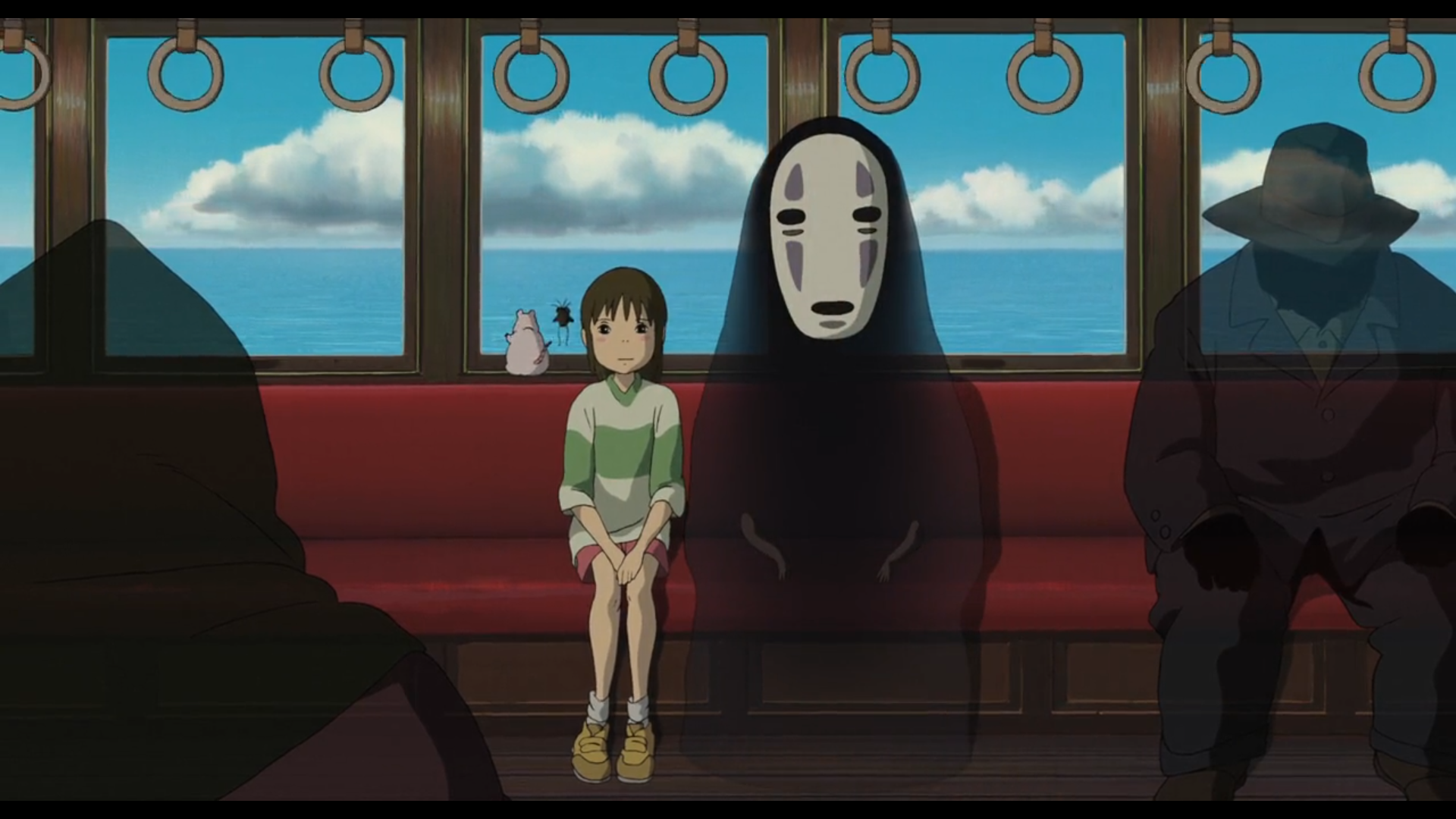 Célèbre scène du Voyage de Chihiro
Au centre, Chihiro, jeune fille japonaise d'une dizaine d'années, aux cheveux châtains foncés, yeux noirs, portant un clair avec une large bande vert pistache au niveau du torse, un short rose, des baskets jaunes, avec des chaussettes blanches qui remontent, et le Sans-Visage, être humanoïde de grande taille, de couleur noire, portant un masque comportant les trous pour des yeux cernés et une bouche ainsi que des marques grises au dessus et en dessous des yeux, sont assis sur la banquette rouge d'un train.
Derrière elleux, Boh en souris blanche dodue et une mouche, se tiennent de dos sur le rebord de la fenêtre et observent le paysage traversé en sautillant.
A l'arrière, on voit une immense étendue d'eau et un ciel nuageux.
A droite, on distingue une ombre fantomatique, qui semble être un monsieur assez imposant physiquement, habillé d'un costume et d'un chapeau dont on ne distingue pas le visage, assise aussi sur la banquette. A gauche, au premier plan, on distingue une ombre du même type, indiquant qu'elle est assise sur la banquette en face.
Le train a l'air luxueux, avec un sol couleur bois, des rebords de fenêtres métalliques tirant sur le doré et une série d'anneaux en haut de l'image pour que les éventuel.le.s voyageur.euse.s debout puissent se tenir.
